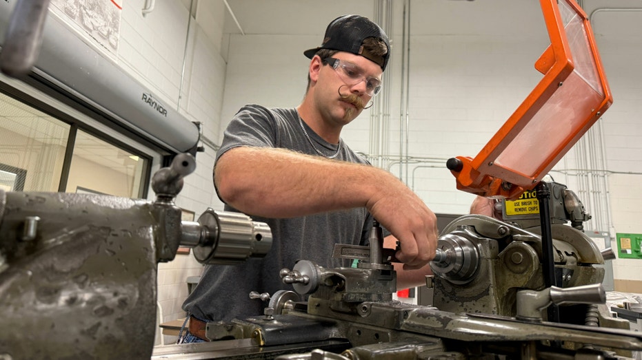 A student works with a lathe.