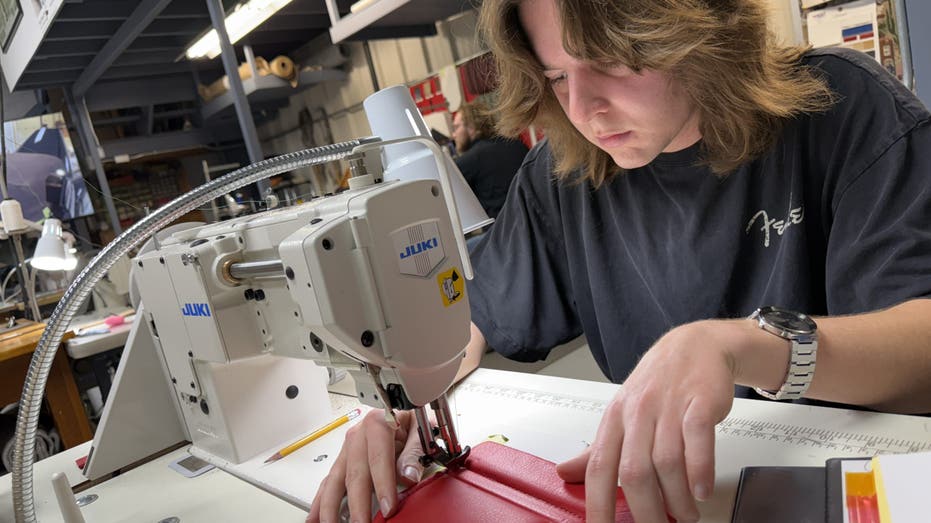 A McPherson College automotive student uses a sewing machine.
