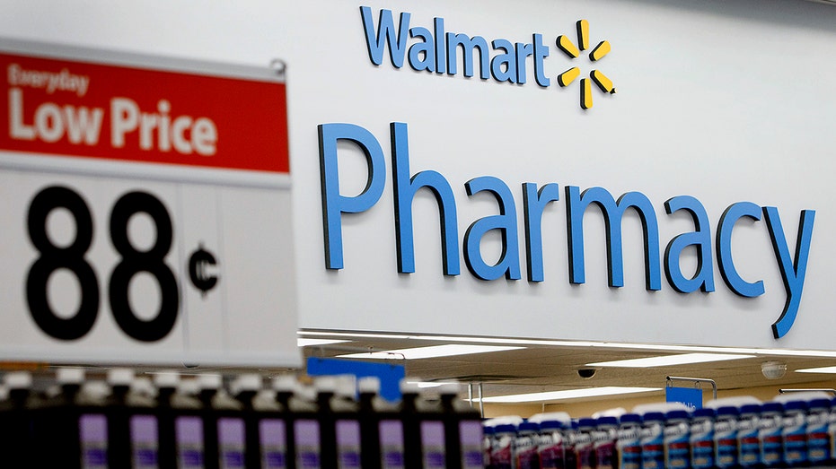 A Walmart low-price sign is displayed by the pharmacy.