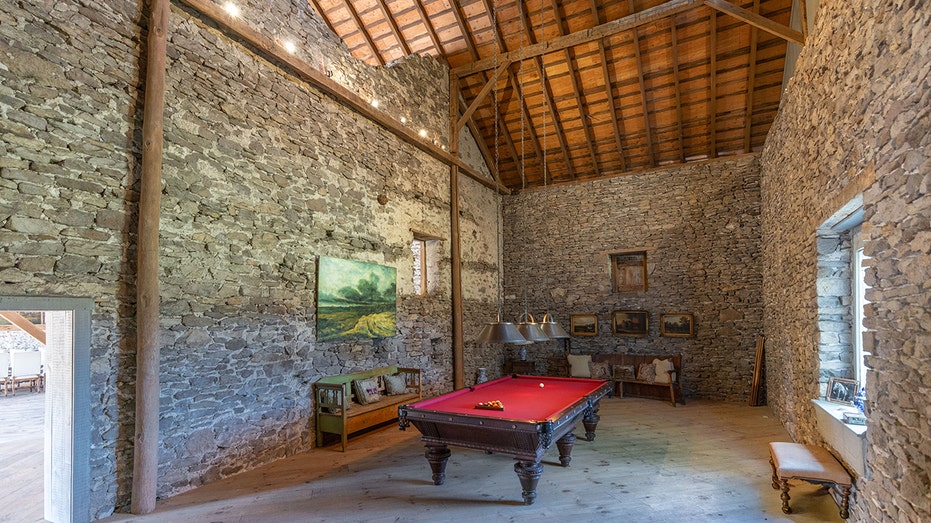 A room with a pool table and high ceilings