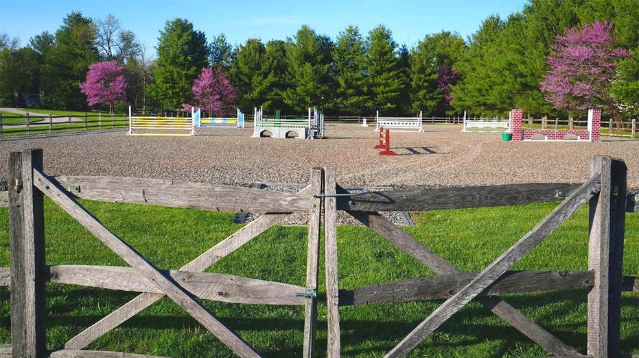 The backyard also includes a jumping arena for horses.