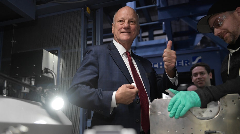 U.S. Treasurer Brandon Beach holds one of the last minted pennies