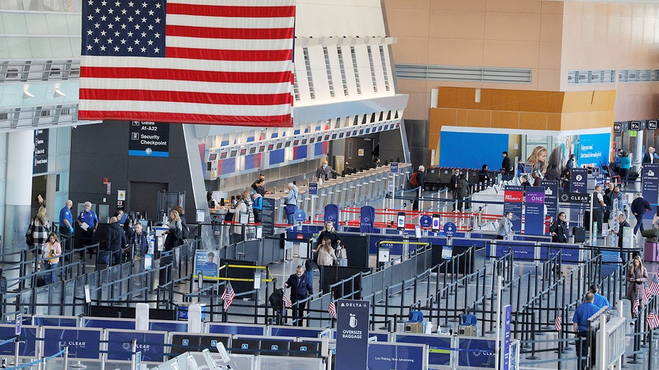 People walk through security checkpoint at Boston airport