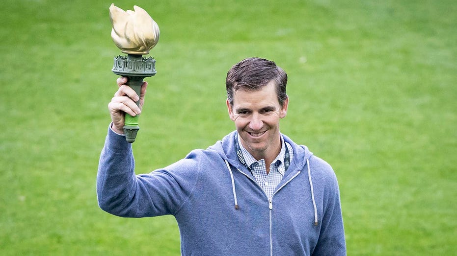 Eli Manning raises torch