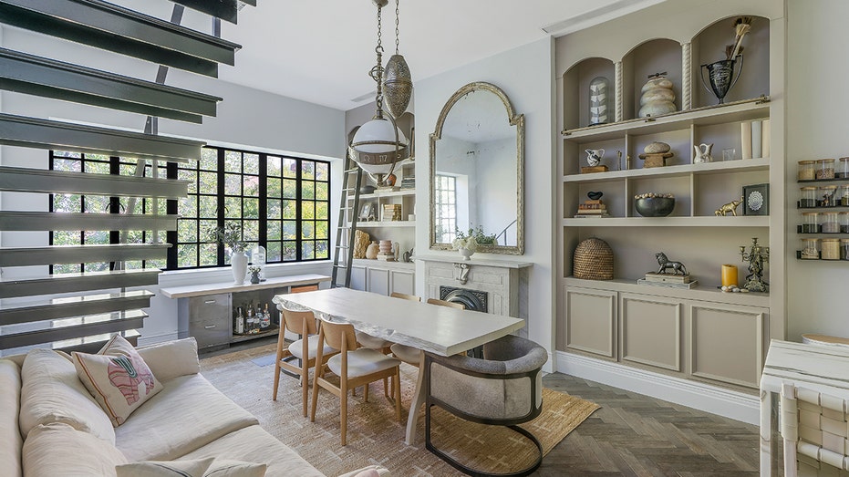 The dining room features built-in shelves, a fireplace and seating.