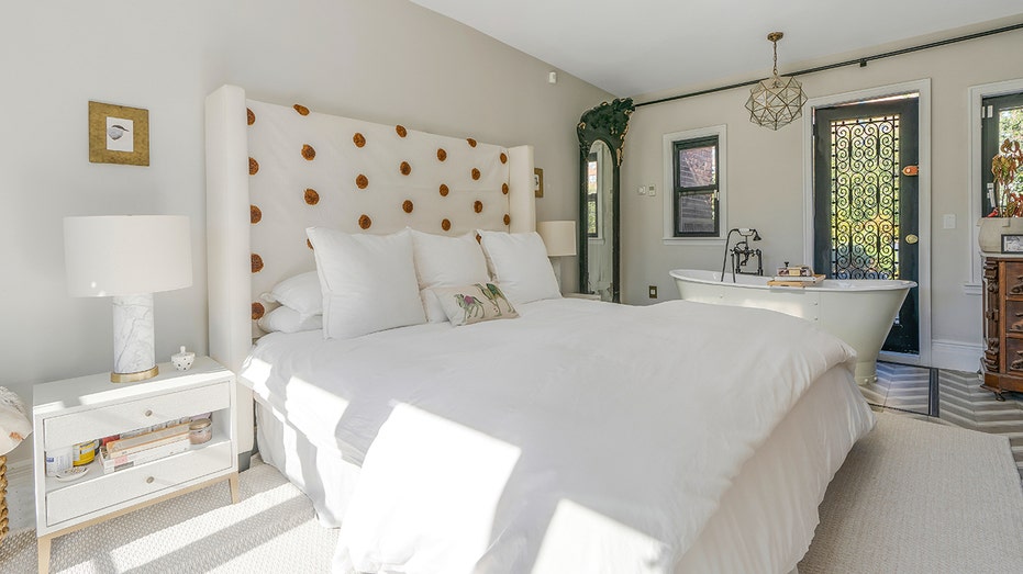 The primary bedroom has a freestanding soaking tub by the bed.