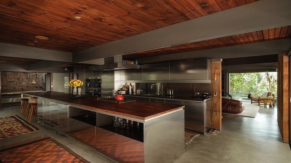 The kitchen features a large island and wood ceiling.