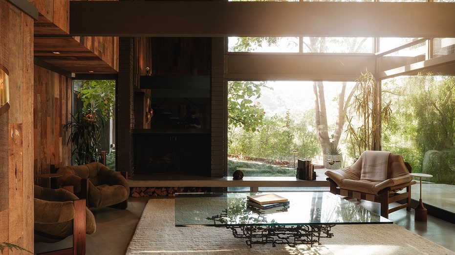 The living room features a fireplace and high ceilings with large windows.