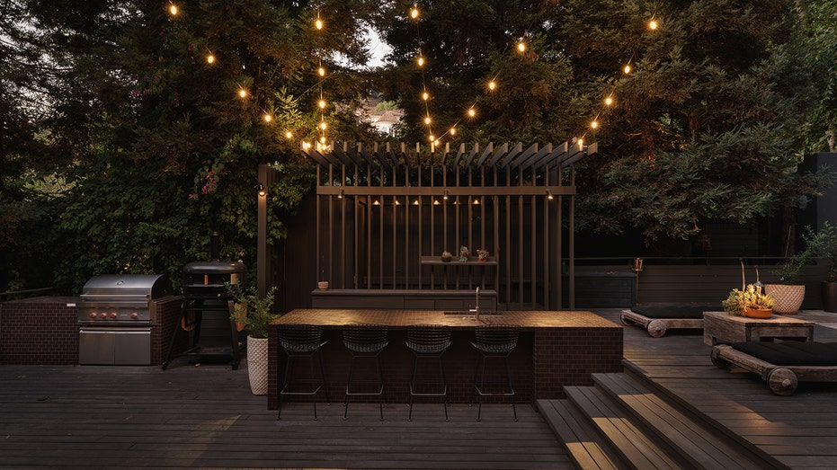 The backyard also includes an outdoor bar and kitchen.