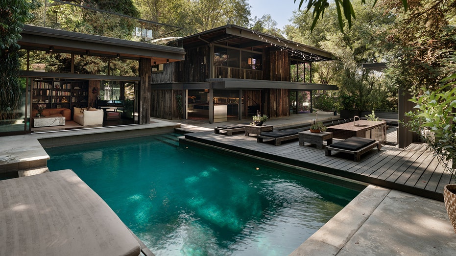 The home also has a large swimming pool and landscaping in the backyard.