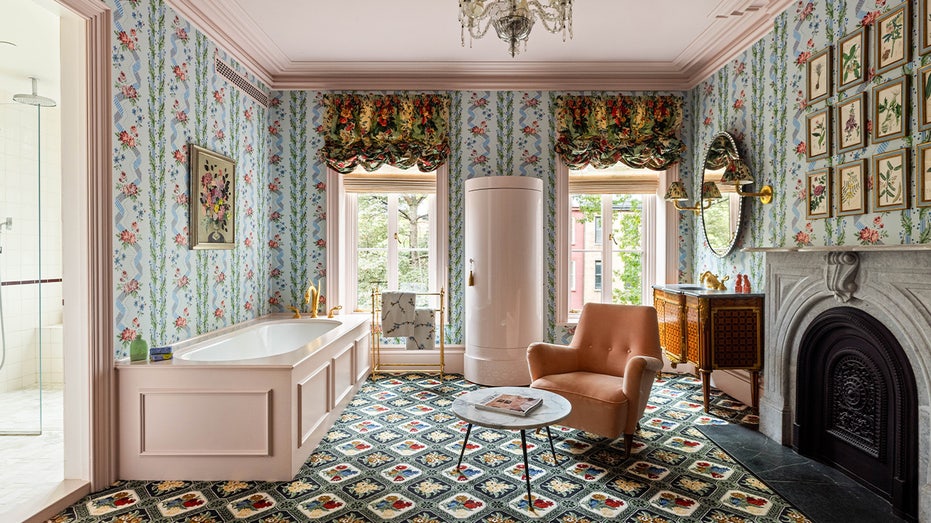 The bathroom has patterned flooring and colorful wallpaper