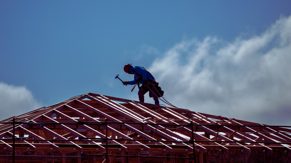 A worker on the roof of a new home being built in California.