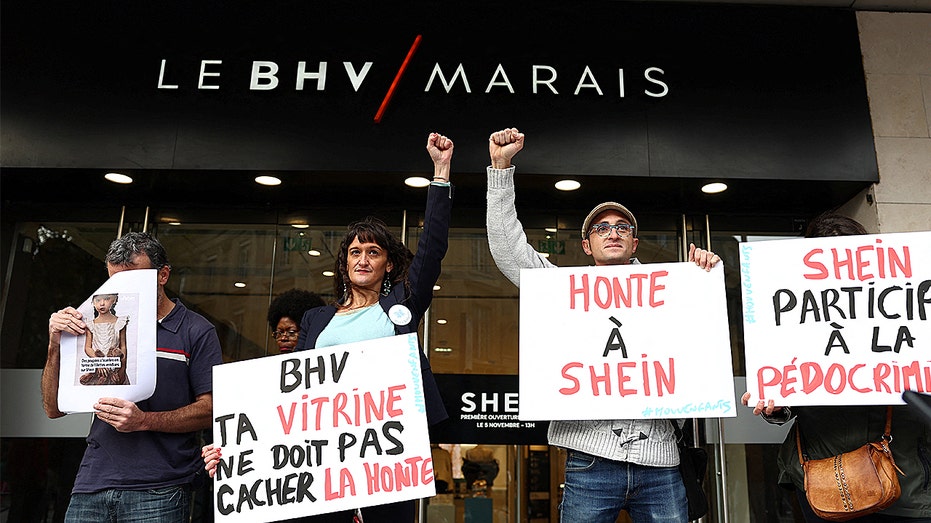 People holding signs to protest fast-fashion retailer Shein.