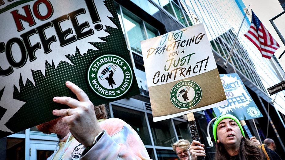 Workers picket in front of a Starbucks