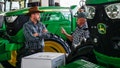 People talk while standing next to tractors at the John Deere exhibition at the NAMPO agricultural festival on May 15, 2025. - Fox News