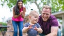 Parents play outside with their baby. - Fox Business News
