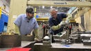 Michael Trevorrow, GM's senior vice president of global manufacturing, is sanding or adjusting part of a metal mold (a die) so it fits exactly with the matching top piece. He&rsquo;s making sure both parts line up correctly before the factory begins using it in production. - Fox Business News