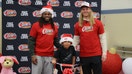 Josh Metellus and Andrew Van Ginkel poses with child at Raising Cane's bike giveaway. - Fox Business News