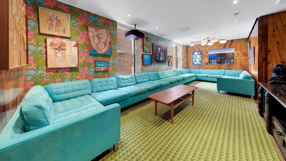 The home features 70s-themed decor, including a picture of flowers and a large blue bed.