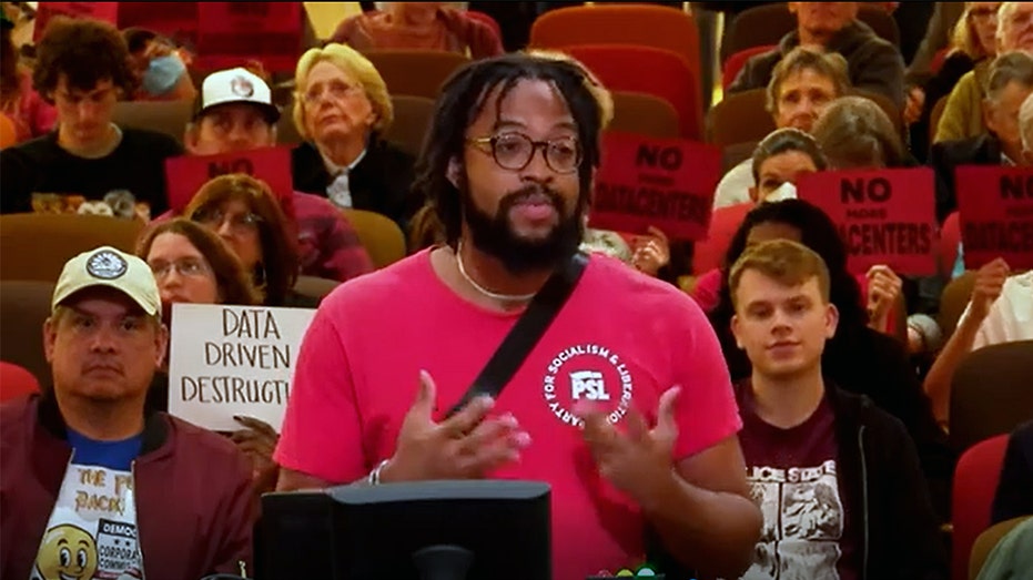 A man speaks in front of a crowd