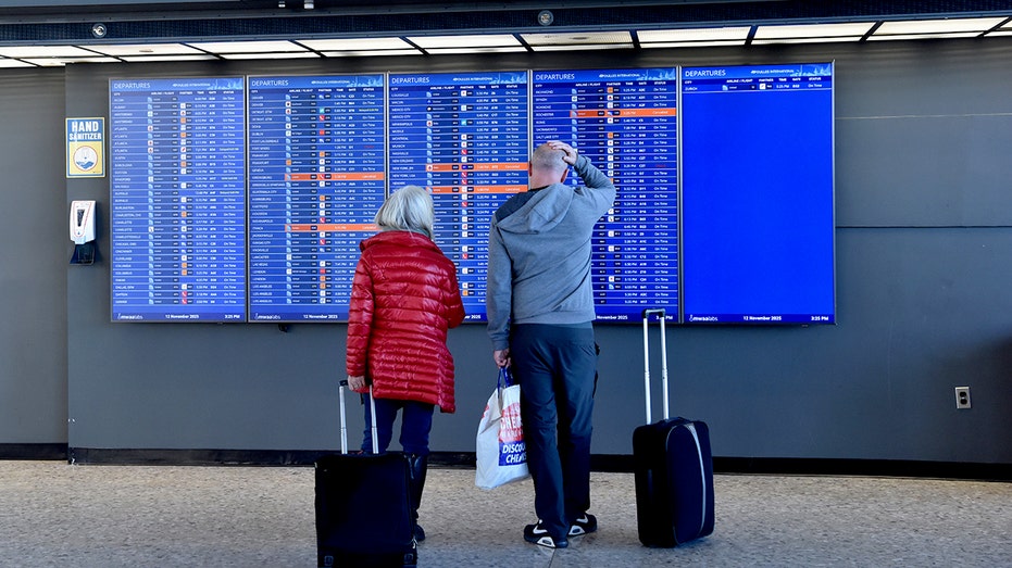 Passengers check departure information at Dulles International Airport on November 12.