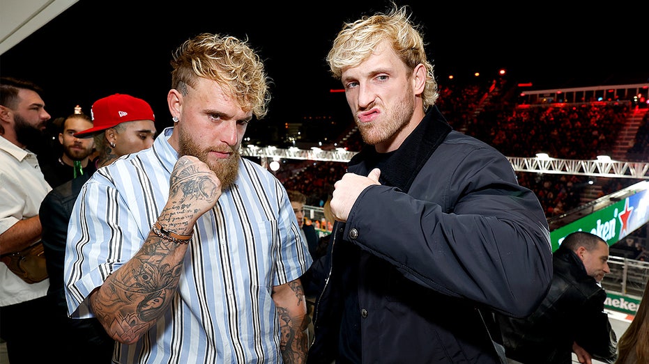 Jake Paul and Logan Paul stand together at a celebrity event during Formula 1 race weekend.