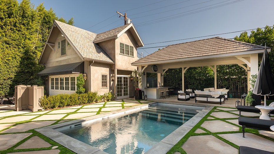 The backyard features a swimming pool, outdoor kitchen and lounge area.