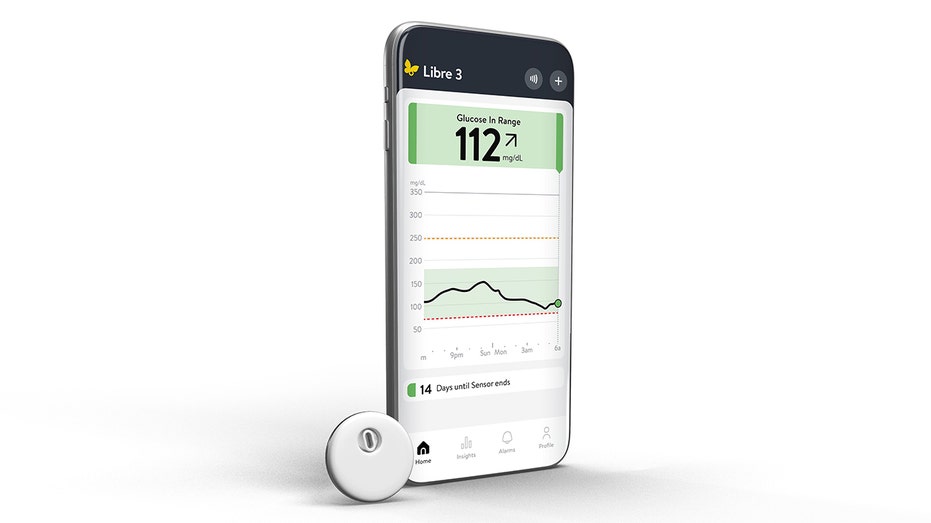 FreeStyle Libre 3 Plus Sensor device with phone depicting glucose monitoring app