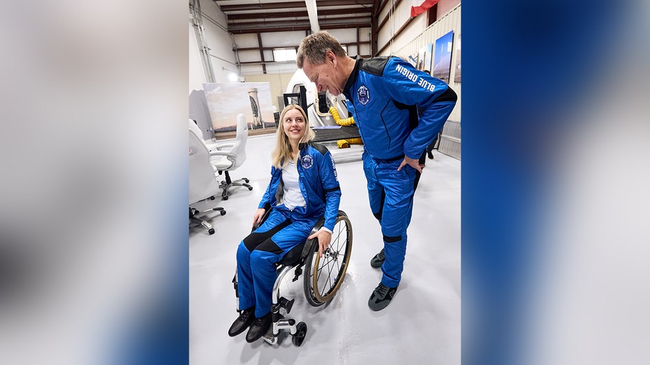 woman in wheelchair next to man wearing blue uniform