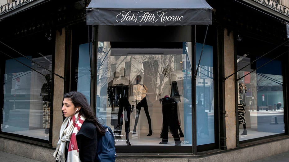 Pedestrians pass by Saks Fifth Avenue Department store in New York.