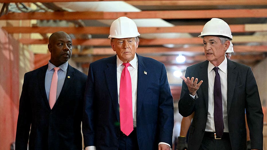 Tim Scott, President Donald Trump, and Jerome Powell tour the new Federal Reserve facility wearing hard hats.