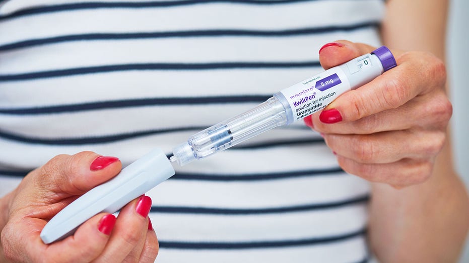 A person holds a Mounjaro pen in London.