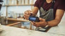 A store employee taps a customer's credit card on a payment machine. - Fox Business News