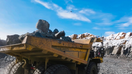USA Mine dump truck carrying big rocks during the day in a mine. - Fox Business News