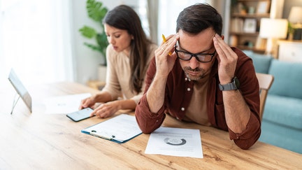 A couple looks stressed over credit reports, as score dropped nationwide, according to a new WalletHub report. - Fox Business News