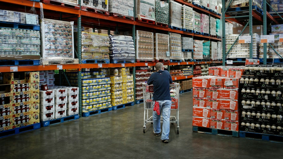 a shopper pushes a cart throught the aisles of costco