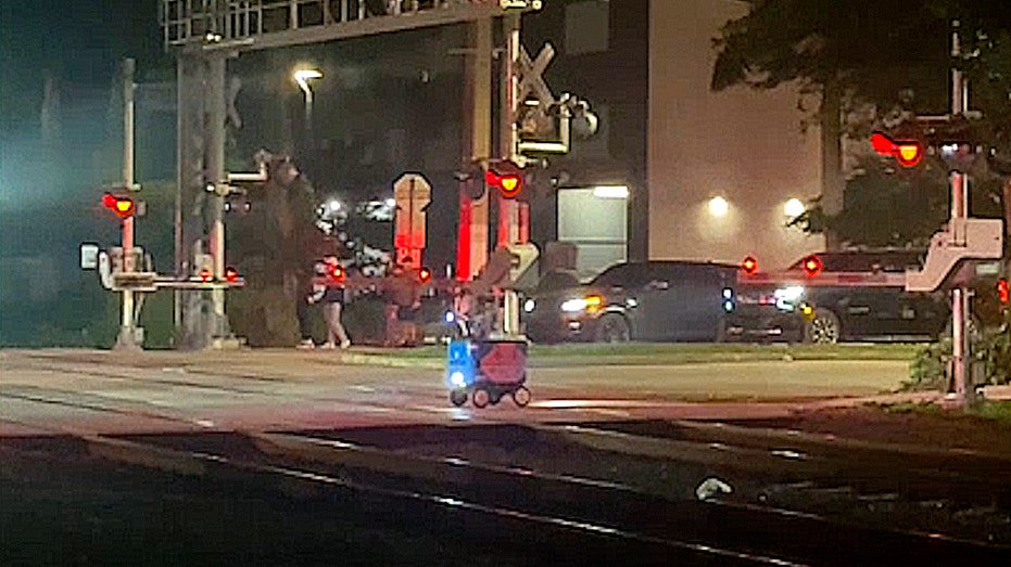 Food delivery robot sits on railroad tracks moments before being hit by a train in Miami.