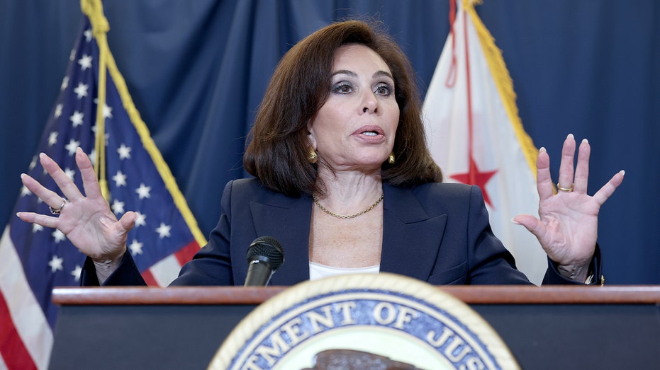 Federal prosecutor speaks at a podium inside a government building during a media briefing.