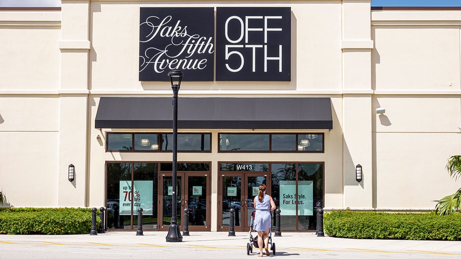 Woman walks towards Saks OFF 5TH store in Florida