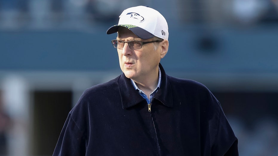 Paul Allen looks on