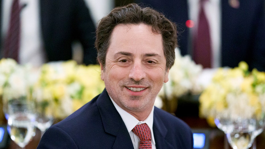 A technology executive sits at a formal dinner table.