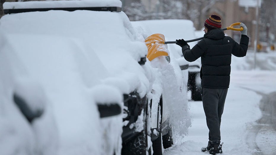 A driver clears snow off his car in Denver, Colorado.