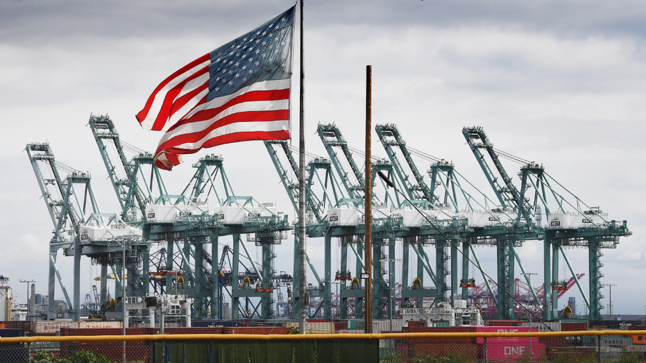 A U.S. flag flies over shipping containers at the Long Beach port in California.
