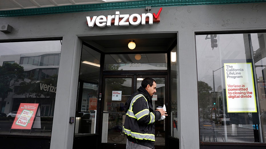 A man walking in front of a Verizon store