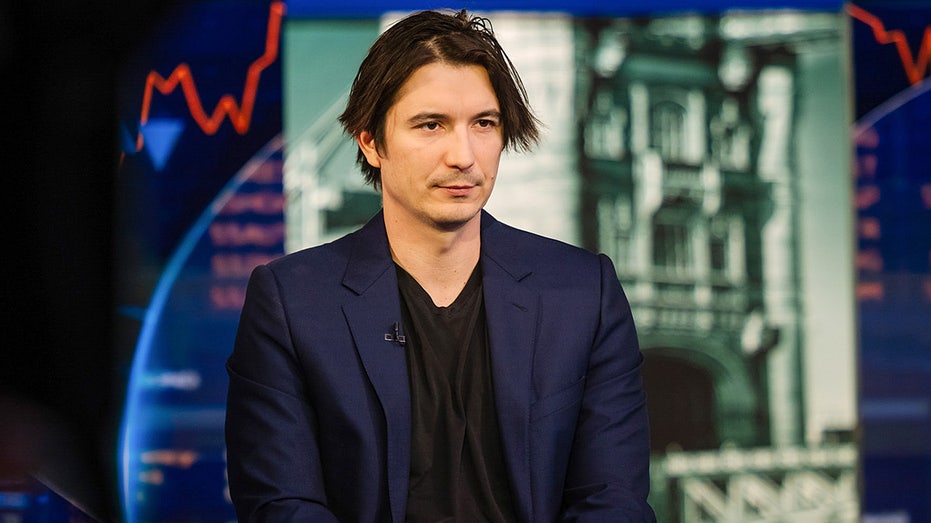 Robinhood CEO Vlad Tenev speaks during a television interview while seated indoors.