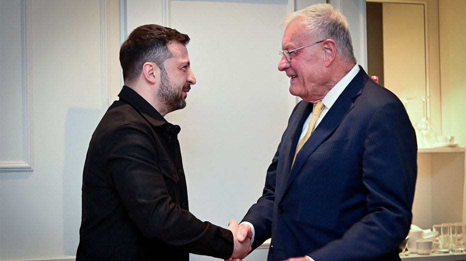 Two officials shake hands before the start of a formal meeting.