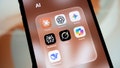 A smartphone screen displays a folder containing AI applications Claude, ChatGPT, Gemini, Perplexity, Grok, Copilot, and DeepSeek. - Fox News