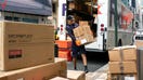 Workers for an independent contractor to FedEx Corp. unload packages from a delivery truck in New York, New York, on June 26, 2023. - Fox Business News