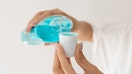 A person pouring mouthwash into a cap - Fox Business News