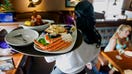 A waitress carries a tray a lobster kettle and a crab trio dish at a Red Lobster restaurant in Yonkers, New York, U.S., on Thursday, July 24, 2014. - Fox Business News